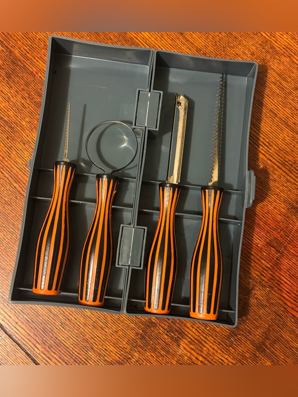 4-piece pumpkin carving tool set featuring black-and-orange handles with case.